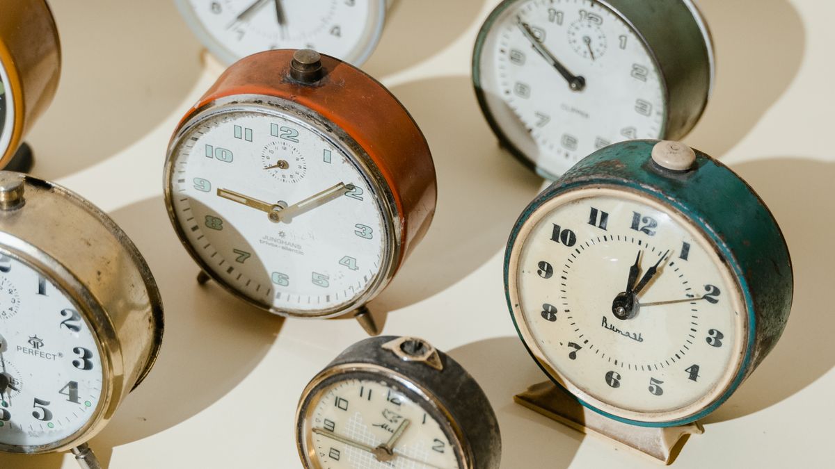 Vintage alarm clocks in warm light, representing birth-time precision